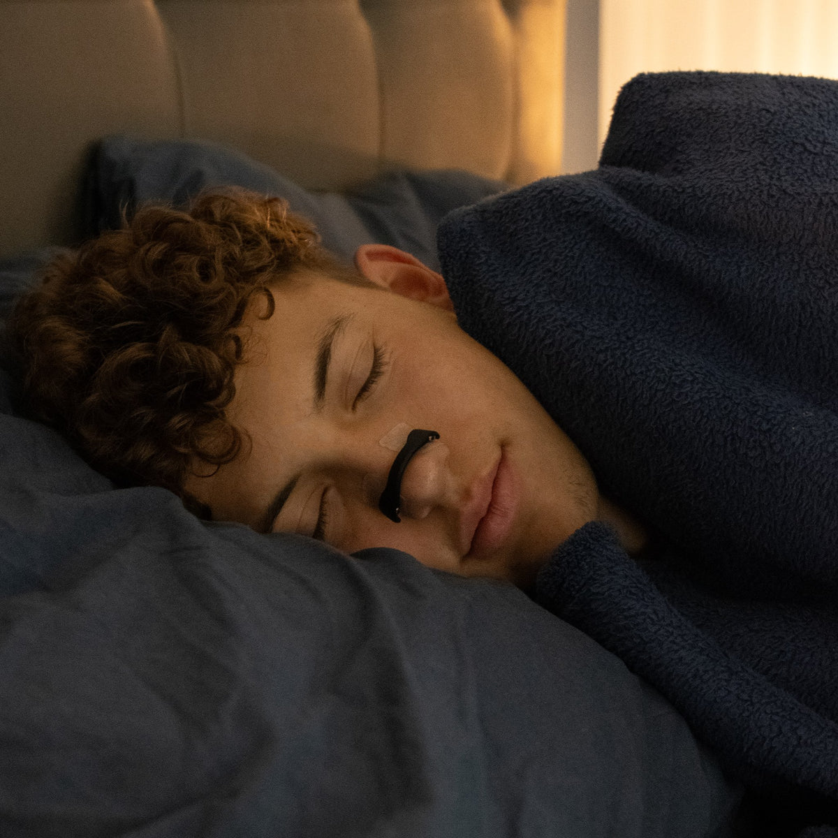 Person sover på siden med sort O² PRO-næseudvider